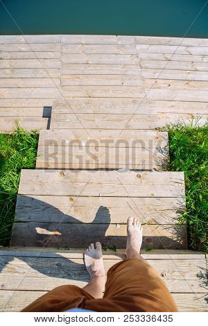 First Person Point Of View. Man Getting Down By Wooden Stairs Of The Dock To Swim. Summer Time.