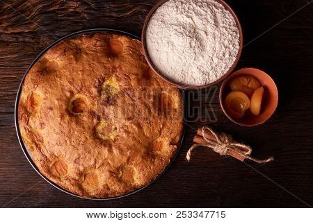 Apricot Pie And A Bowl With Flour And Other Ingredients And Tools Table