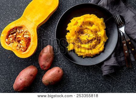 Mashed Potato With Pumpkin In Black Bowl. Dark Background. Top View