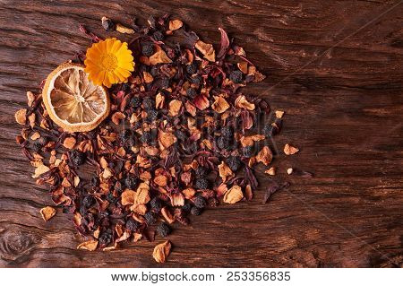 Black Dry Fruit Tea Leaves On Wooden Table. Selective Focus