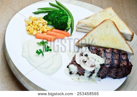 Roasted Black Pepper Lamb Steak With Salads And Fries On A Blue Round Plate. Wooden Texture Backgrou