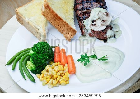 Roasted Black Pepper Lamb Steak With Salads And Fries On A Blue Round Plate. Wooden Texture Backgrou