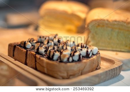 Sliced Toasted Bread With Marshmello Topping With Chocolate Sauce On Wooden Plate. Food And Drinks C