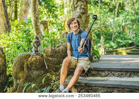 Selfie With Monkeys. Young Man Uses A Selfie Stick To Take A Photo Or Video Blog With Cute Funny Mon