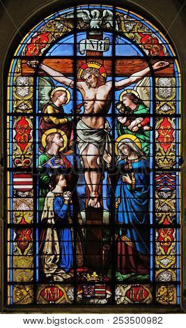 PARIS, FRANCE - JANUARY 10: The Crucifixion by Lusson, central stained glass window in the Basilica of Notre Dame des Victoires in Paris, France on January 10, 2018.