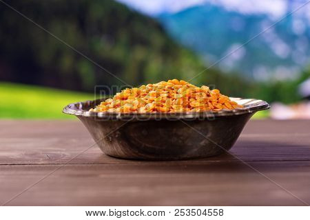 Lot Of Whole Raw Red Lentils In Old Iron Bowl With Country Nature In Background