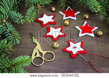 Christmas Party Preparation Background With Sewing Star Figures From Red Anf White Felt, Needle With