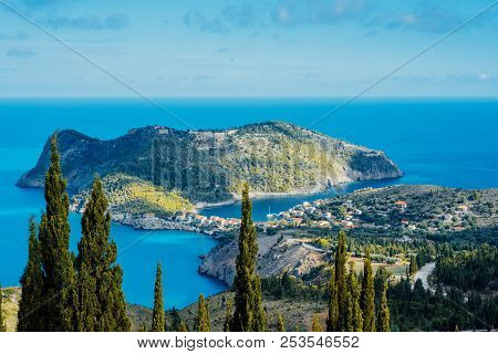 Above View To Assos Village And Beautiful Blue Sea. Cypress Trees Stands Out In Foreground. Kefaloni