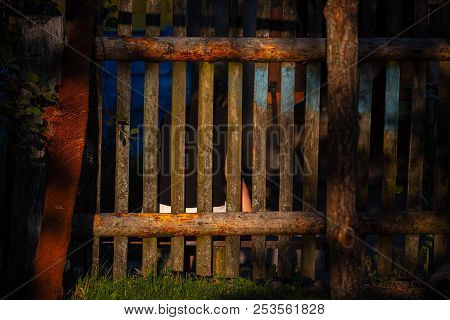 Sunshine Creating Lens Flare Through A Wooden Picket Fence In A Front Yard, Front Garden With Artifi