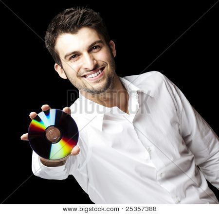 portret przystojny młody mężczyzna trzyma cd na czarnym tle
