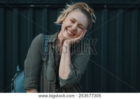 Urban People Concept. Carefree Young Woman Portrait Smiling, Dressed In A Khaki Romper With A Backpa