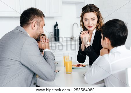 Partial View Of Family Praying Together During Breakfast At Home