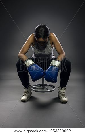 Black Female Wearing Boxing Gloves Looking Angry As A Boxer, Mma Fighter Or Self Defense Trainer Sit