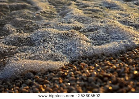 Small Waves Coming Into The Shoreline During Golden Hour Along The Coast.a Bold And Dramatic Scene O