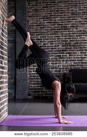 Beginning Female Yogi Practicing Yoga Inversion Poses Standing On Hands Upside Down Leaning Against 