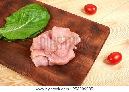 Raw Turkey Fillet Pieces On A Cutting Board Wooden Background