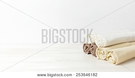 Multicolored Clean Towels On A Light Wooden Background With Copy Space. Texture Of Cotton, Waffle To