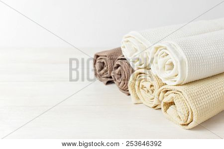 Multicolored Clean Towels On A Light Wooden Background With Copy Space. Texture Of Cotton, Waffle To