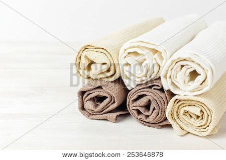 Multicolored Clean Towels On A Light Wooden Background With Copy Space. Texture Of Cotton, Waffle To