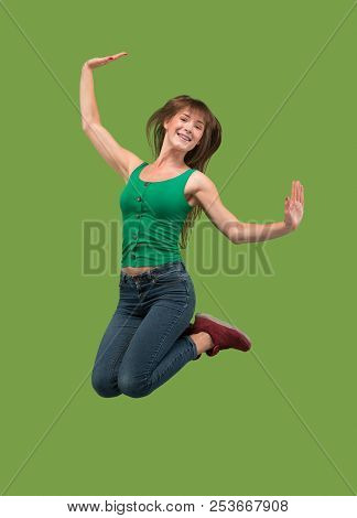 Freedom In Moving. Mid-air Shot Of Pretty Happy Young Woman Jumping And Gesturing Against Orange Stu