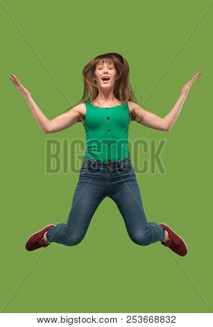 Freedom In Moving. Mid-air Shot Of Pretty Happy Young Woman Jumping And Gesturing Against Orange Stu
