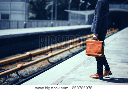 Businessman In Suit Standing At Empty Train Platform. Cropped Picture Of Gentelmen In Suit With Brow