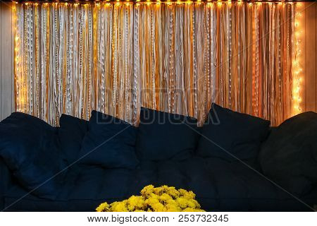 Comfortable Navy Blue Sofa In Living Room With Flowers In Front And Yellow Led Decorative Lights On 