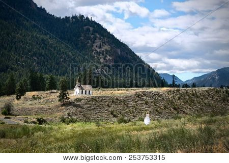 Woman In White Dress Walking To The Church. Little Church On Hill. Keremeos. Ocanagan. British Colum