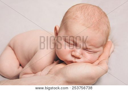 Portrait Of Newborn Baby Lying On The Hands Of Parents. The Concept Of Newborn Health