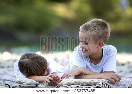 Two Young Happy Cute Blond Laughing Children, Boy And Girl, Brother And Sister Having Fun On Pebbled