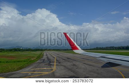Airport Runway With Airplane Wing In Sunny Day.