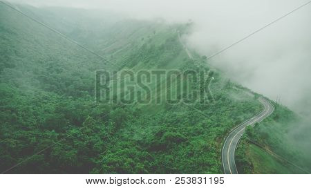 Aerial Top View Of Sky Road Over Top Of Mountain With Fog And Green Jungle After Raining In Morning