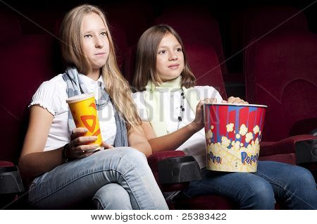 zwei schöne Mädchen, die einen Film im Kino
