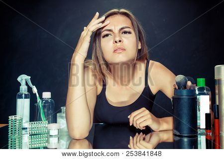 Unsatisfied Unhappy Young Woman Looking At Her Self In Mirror On Black Studio Background. Roblem Ski