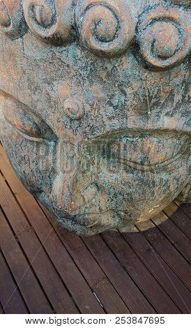 Buddha Face Close Up On Wooden Background