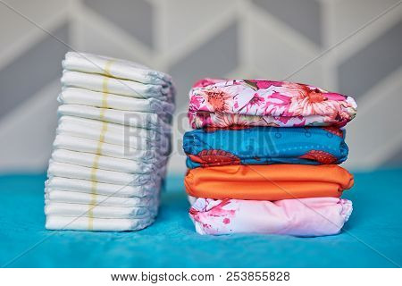 Two Piles Of Diapers. Cloth Diaper Stack And One Time Use Diaper Pile