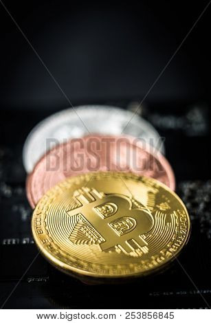 Coins of bitcoin on dark background. Golden bitcoin, silver bitcoin, bronze bitcoin on lying on grey background, close-up