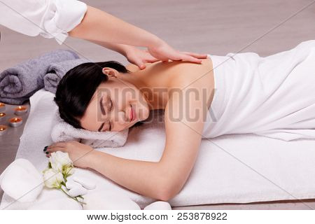 A Fragrant Massage On The Floor.young Woman Enjoying Massage In Spa Salon