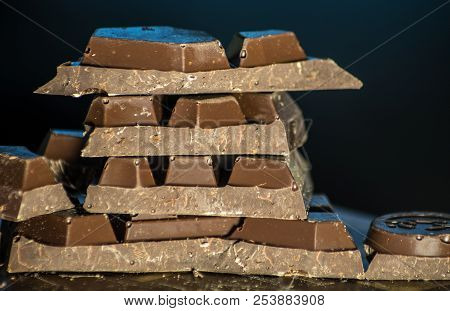 Dark Chocolate Bars Stacked Up With Dark Background In The Ktichen