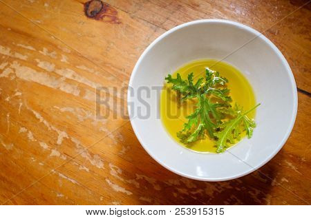 A Citronella Plant Leaf Resting In Oil To Make Homemade Mosquito Repellant