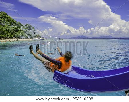 Asian Man Playing The Slider On The Boat With Amzing Idyllic Ocean And Blue In Vacation Time.summer 