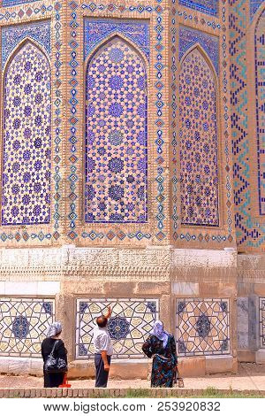 Samarkand, Uzbekistan - May 19, 2011: Local Uzbek Tourists Observing The Architectural Details Of Bi