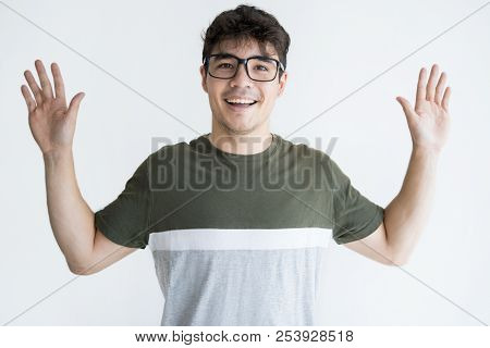 Portrait Of Cheerful Young Asian Man In Glasses Raising Hands. Vietnamese Male Student Standing With