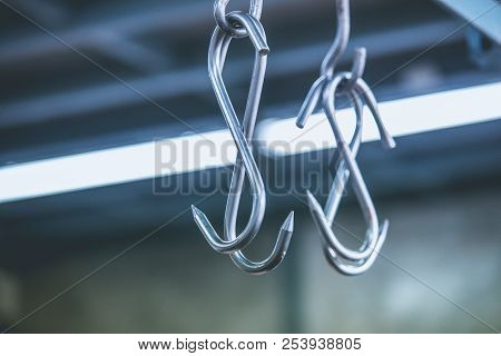 Meat Hooks Hanging In A Slaughterhouse Or Butchery