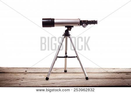 Telescope On A White Background Laid On Wooden Board