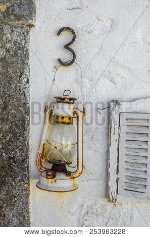 Old oil lantern hanging on a white wall