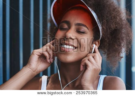 Young Woman In Tennis Visor And Earphones Free Style On The Stre