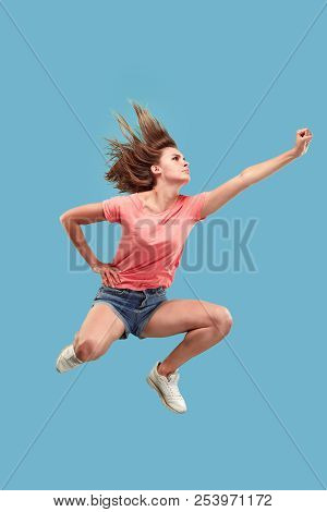 Freedom In Moving. Move Only Forward. Pretty Happy Young Woman Jumping And Gesturing Against Blue St