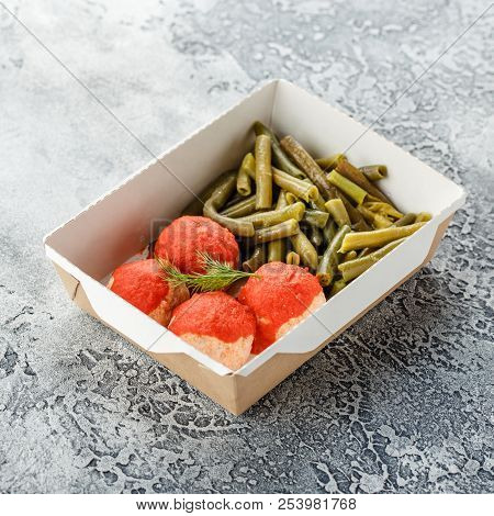 Boiled String Beans And Fish Balls In Sauce In A Lunchbox On A Gray Background. Healthy Food Deliver