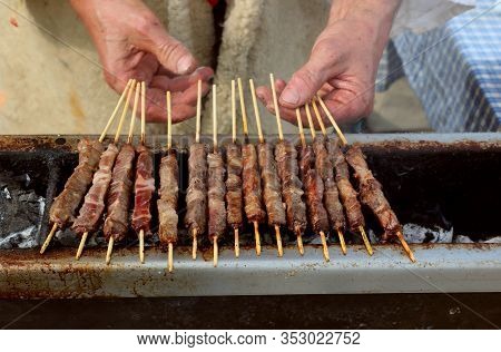 Hands Of The Cook Who Cooks Mutton Skewers Called Arrosticini In Italian Language